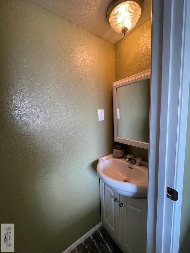 bathroom with vanity and a textured ceiling