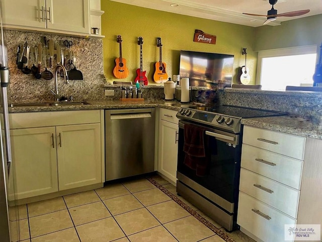 kitchen featuring appliances with stainless steel finishes, backsplash, ceiling fan, sink, and light tile patterned floors