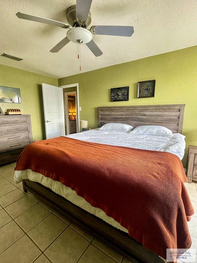 tiled bedroom with a textured ceiling and ceiling fan