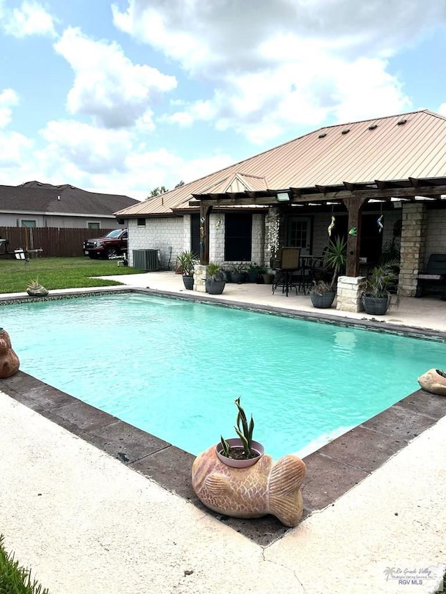 outdoor pool with fence, a patio area, and central AC unit