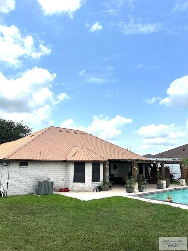 rear view of property with stone siding, a patio, an outdoor pool, a lawn, and cooling unit