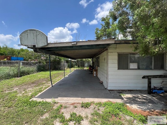 view of parking / parking lot featuring a yard and a carport