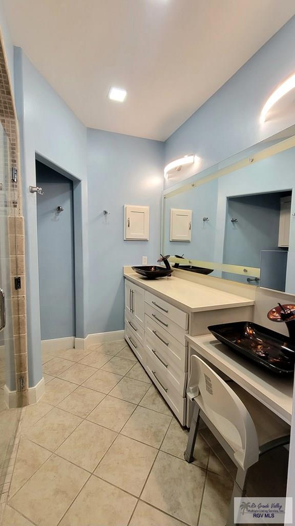 3429 E Country Club Dr, Edinburg, TX 78542 - bathroom featuring a sink, tile patterned flooring, a shower stall, and double vanity