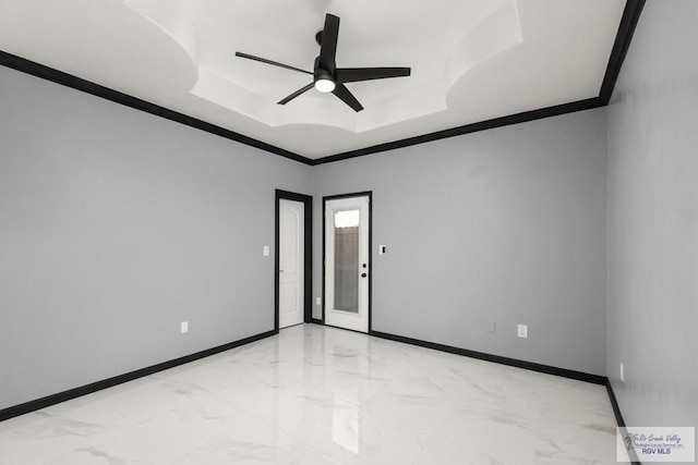 unfurnished room featuring a tray ceiling, ceiling fan, and ornamental molding