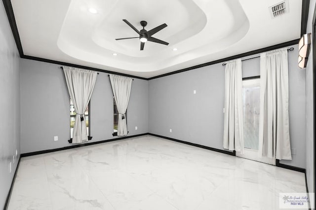 unfurnished room with a tray ceiling, ceiling fan, and crown molding