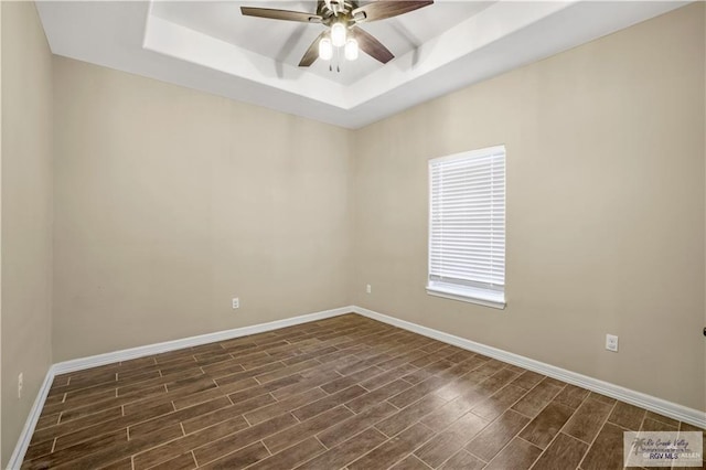 unfurnished room featuring a raised ceiling and ceiling fan