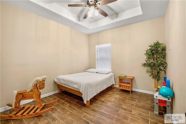 bedroom featuring ceiling fan and a raised ceiling