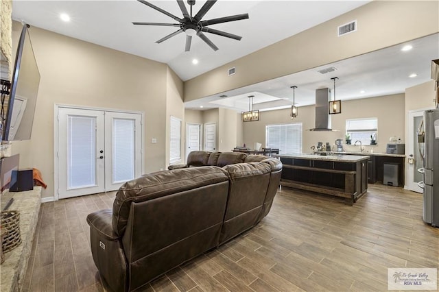 living room featuring ceiling fan and french doors