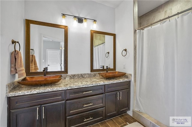 bathroom featuring walk in shower and vanity