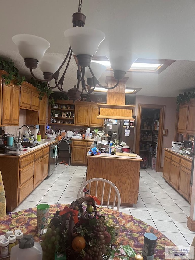 635 S San Marcelo Blvd, Brownsville, TX 78526 - kitchen featuring light tile patterned floors, stainless steel appliances, a kitchen island, brown cabinetry, and light countertops