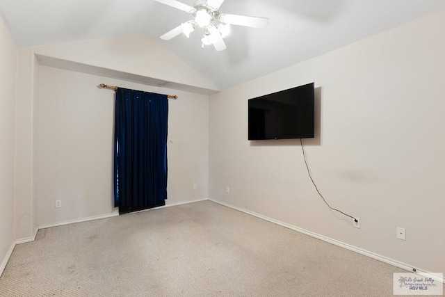 spare room with a ceiling fan, lofted ceiling, carpet, and baseboards