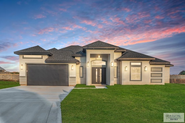 prairie-style house featuring a lawn and a garage