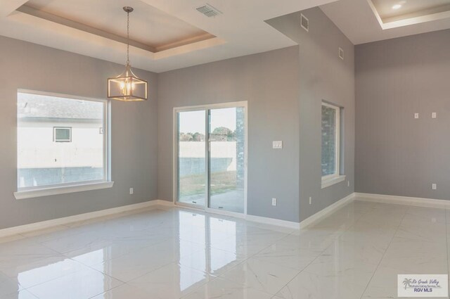 unfurnished room featuring a tray ceiling