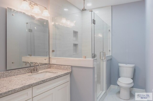 bathroom with vanity, toilet, and a shower with door