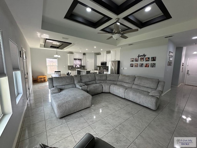 living room featuring ceiling fan, visible vents, baseboards, coffered ceiling, and recessed lighting