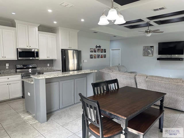 kitchen featuring visible vents, a ceiling fan, appliances with stainless steel finishes, and a kitchen island