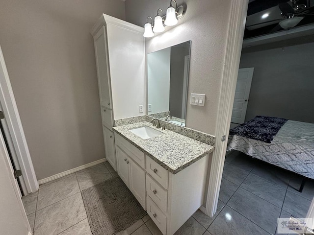 bathroom with vanity, baseboards, tile patterned flooring, and a chandelier