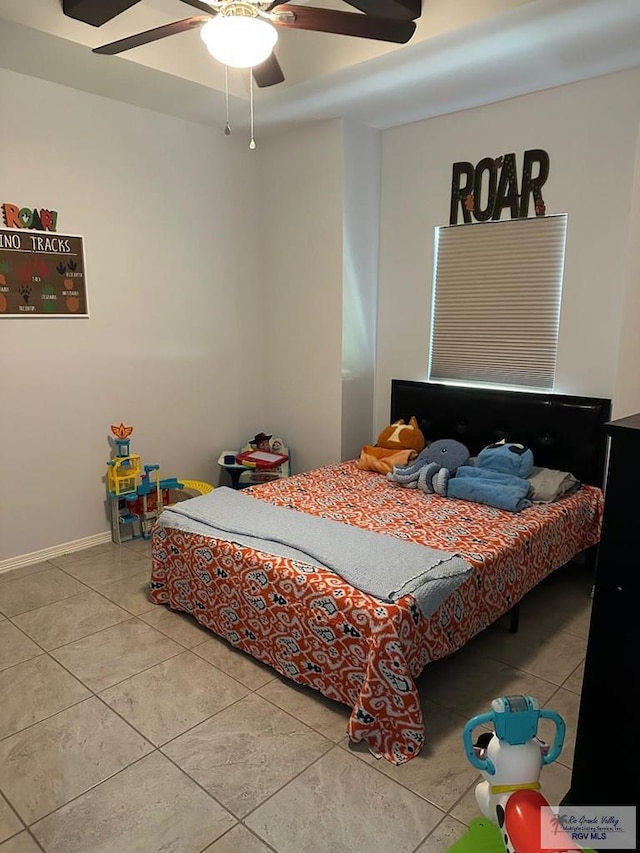 tiled bedroom featuring a ceiling fan and baseboards