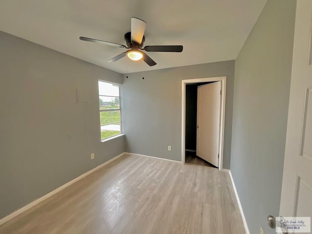 unfurnished room featuring ceiling fan, baseboards, and light wood finished floors
