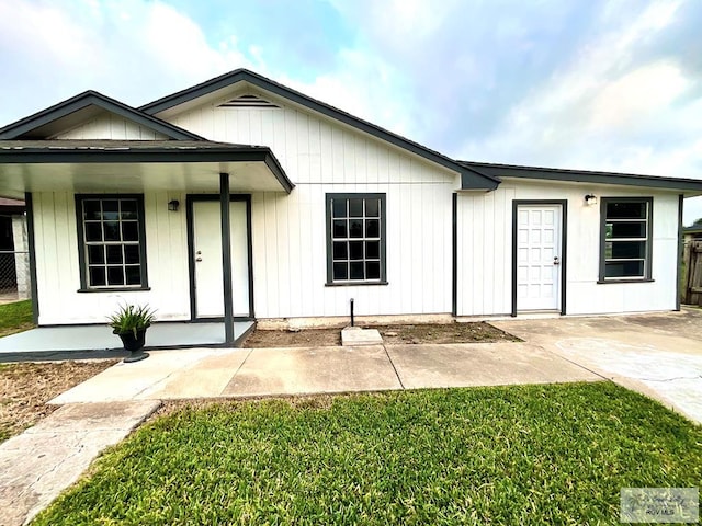 view of front facade featuring a front yard, covered porch, and fence
