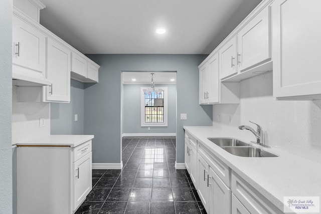 27859 Mile 3, La Feria, TX 78559 - kitchen with a sink, baseboards, white cabinets, light countertops, and recessed lighting