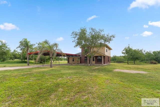 27859 Mile 3, La Feria, TX 78559 - view of front of house featuring driveway, a front yard, a carport, brick siding, and a gazebo