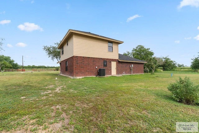 27859 Mile 3, La Feria, TX 78559 - view of home's exterior with brick siding, central AC unit, and a lawn