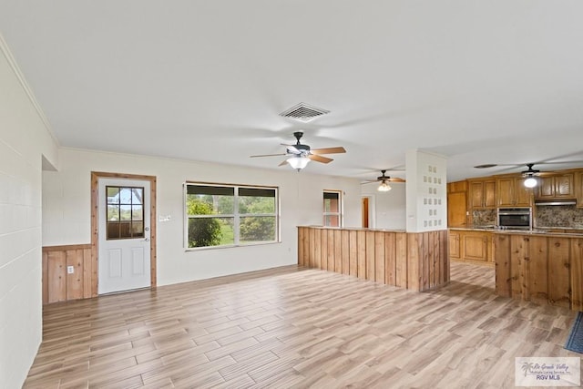 unfurnished living room featuring light hardwood / wood-style floors and ornamental molding