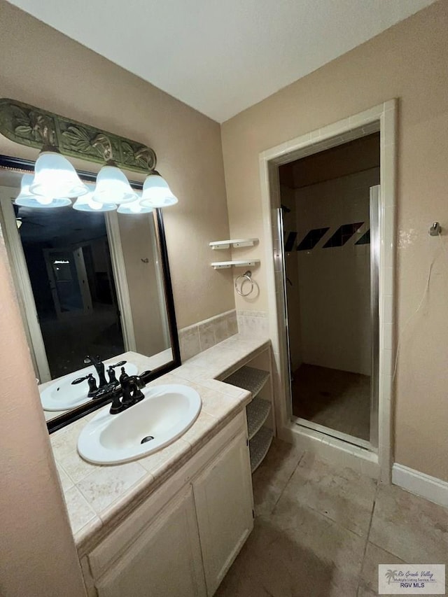 bathroom with tile patterned flooring, vanity, and walk in shower