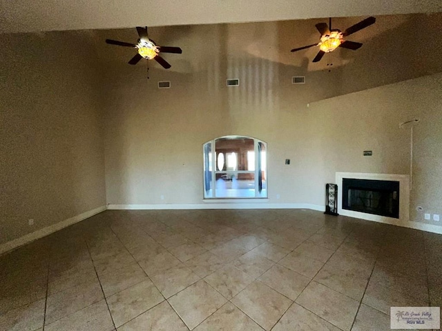 unfurnished living room featuring high vaulted ceiling, ceiling fan, and light tile patterned flooring