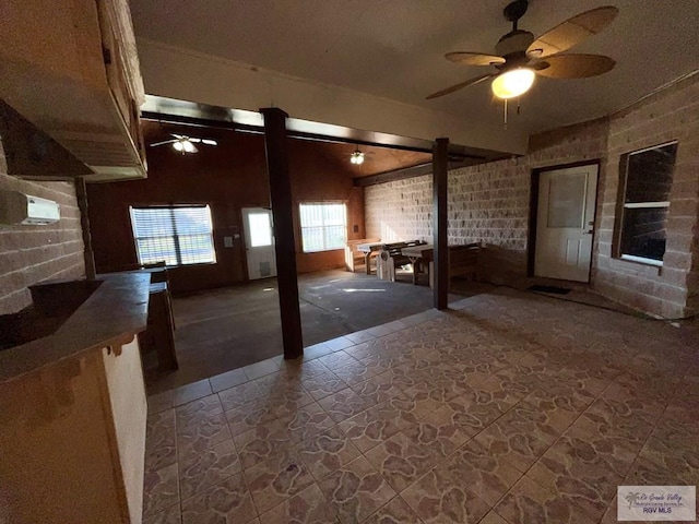 basement featuring ceiling fan and brick wall