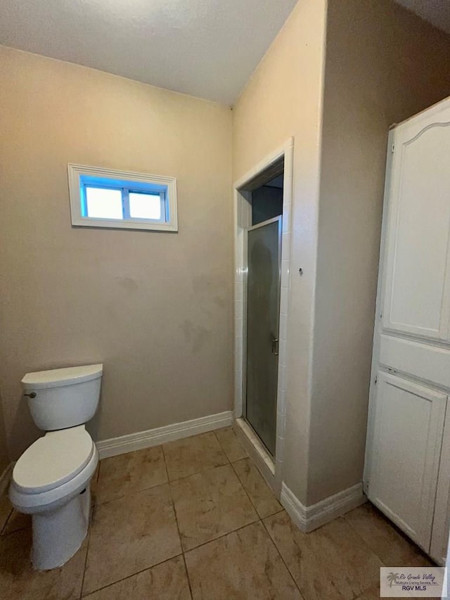 bathroom featuring walk in shower, tile patterned floors, and toilet