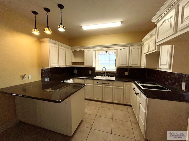 kitchen with electric cooktop, white cabinetry, kitchen peninsula, and sink