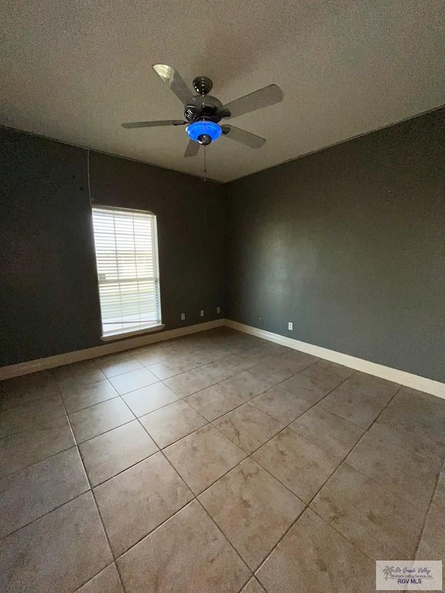 tiled spare room featuring ceiling fan and a textured ceiling