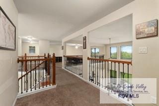 hallway featuring dark colored carpet