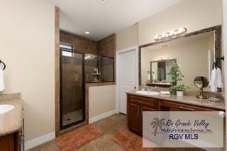 bathroom with tile patterned flooring, vanity, and walk in shower