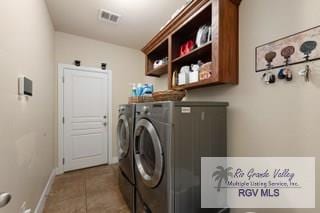 clothes washing area featuring light tile patterned flooring, cabinets, and independent washer and dryer