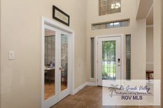 doorway to outside featuring dark tile patterned flooring and french doors