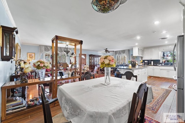 dining space with light hardwood / wood-style flooring, ceiling fan, and crown molding