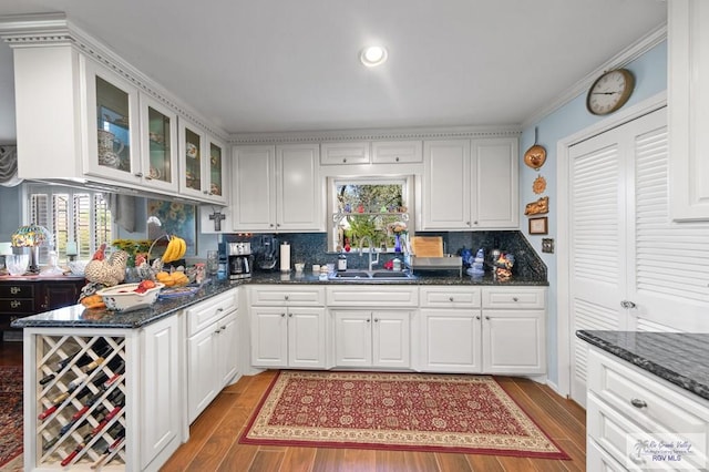 kitchen with hardwood / wood-style floors, white cabinetry, and sink