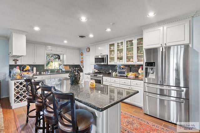 kitchen with white cabinets, appliances with stainless steel finishes, and light wood-type flooring