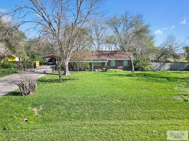 ranch-style house with a front yard and a carport