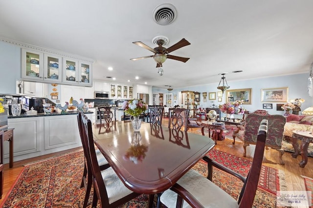 dining space with ceiling fan and light hardwood / wood-style floors