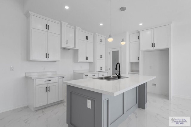 kitchen with white cabinetry, an island with sink, and pendant lighting