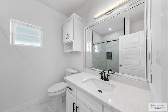 bathroom featuring vanity, toilet, and a shower with shower door