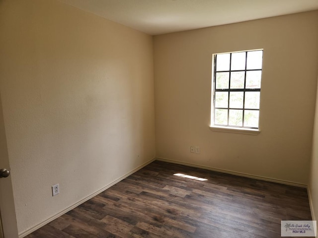 unfurnished room with dark wood-type flooring