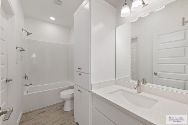 full bathroom with wood-type flooring, vanity, toilet, and shower / tub combination