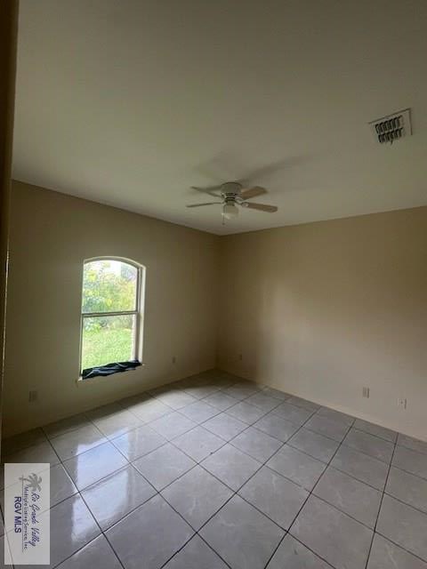 tiled empty room with ceiling fan