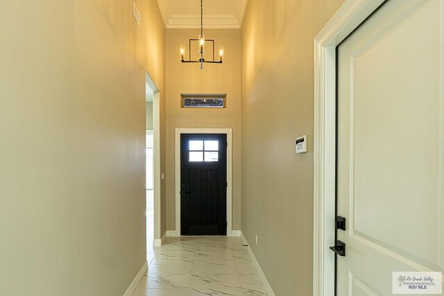 8801 Swan Lake Dr # 24, Harlingen, TX 78552 - doorway to outside with marble finish floor, baseboards, crown molding, and an inviting chandelier