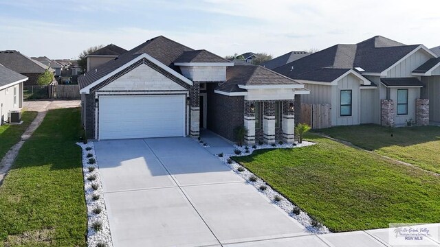 8801 Swan Lake Dr # 24, Harlingen, TX 78552 - view of front of home with driveway, a garage, central air condition unit, a front lawn, and board and batten siding
